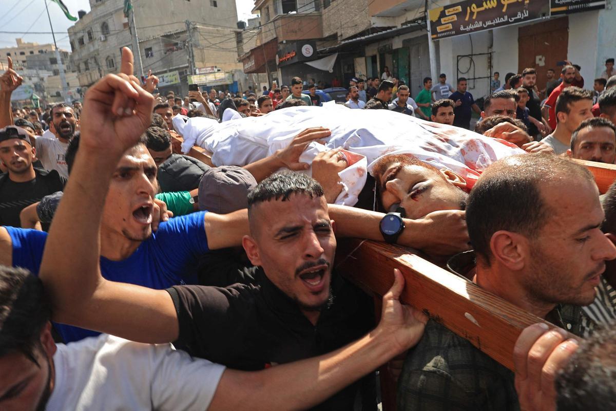 Ciudadanos palestinos llevan el cuerpo de una víctima muerta en un ataque aéreo israelí en Khan Yunis, en la parte suroeste de la Franja de Gaza.