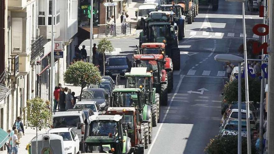 Los ganaderos, ayer, recorriendo las calles de Vilalba con sus tractores durante una protesta.