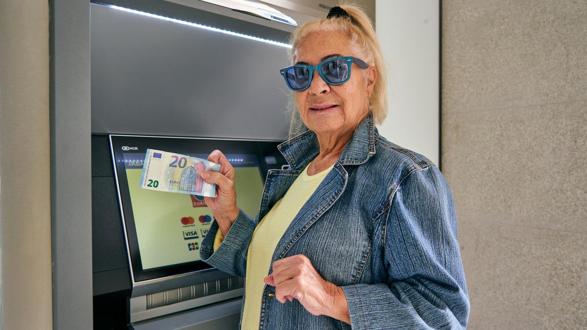 Isabel Zaballos sacando dinero de un cajero automático cacereño.