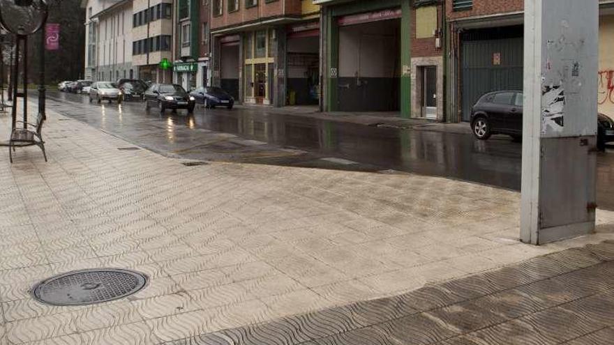 En primer término, la acera sin limpiar, y a continuación, el tramo en el que actuó la máquina decapadora en la avenida de Oviedo de Sama.