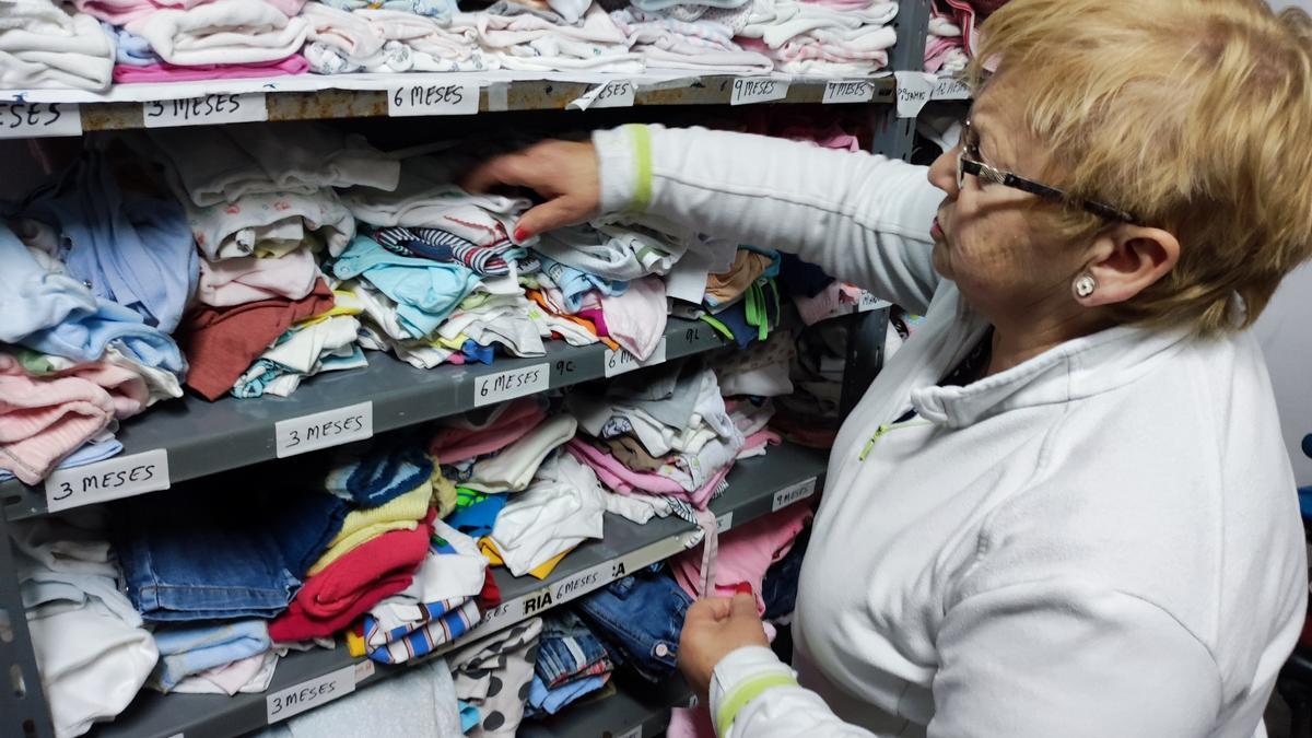 Matilde Gayol colocando las prendas de bebé.