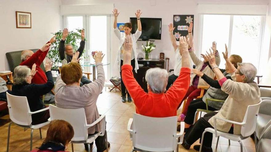 Un grupo de mayores hace gimnasia en una residencia.