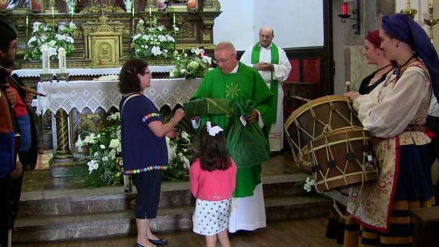 El párroco, en presencia de su sustituto, recoge los obsequios tras el &quot;Asturias, patria querida&quot; a la gaita.