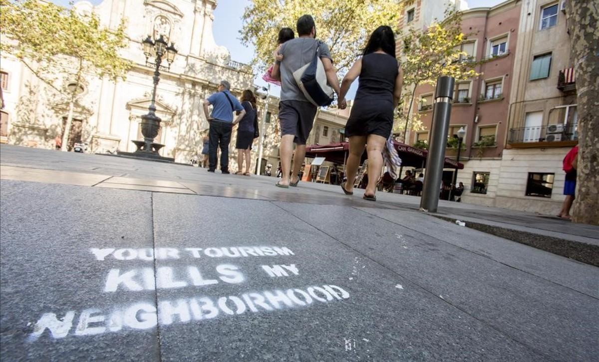 Pintadas contra el turismo y los pisos turisticos en la Placa de la Barceloneta    