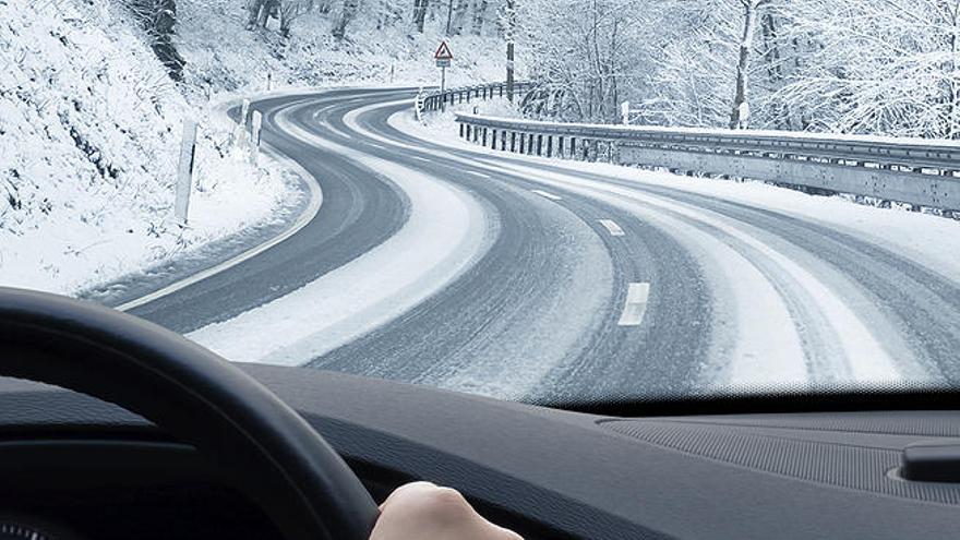 Un vehículo circula por una carretera con nieve.