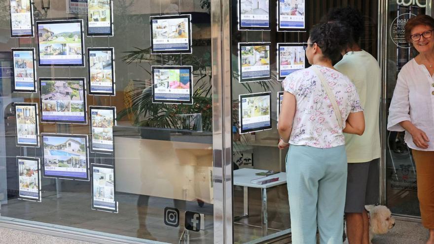 Ciudadanos viendo anunciosde pisos en una inmobiliaria de Vigo.