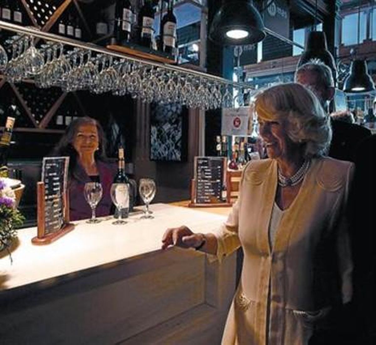 A dalt, Camil·la, al mercat de San Miguel, on va degustar algunes tapes. Al costat d’aquestes línies, Letizia dóna la benvinguda al príncep Carles a la seva arribada a Madrid. A l’esquerra, la duquessa de Cornualla saluda la d’Alba al Palau Reial.