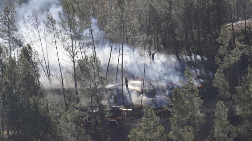 Los bomberos en las tareas de extinción, ayer. | EFE/MANUEL BRUQUE