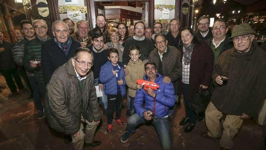 Alfredo Llaneza, en el centro y con gafas, junto a su esposa, Paloma Llera, ayer, rodeados de clientes y amigos, ante su cafetería.