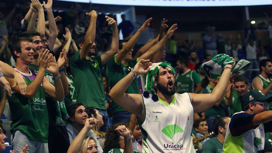 Los aficionados del Unicaja esperan la colocación de las banderolas en el techo del Carpena.