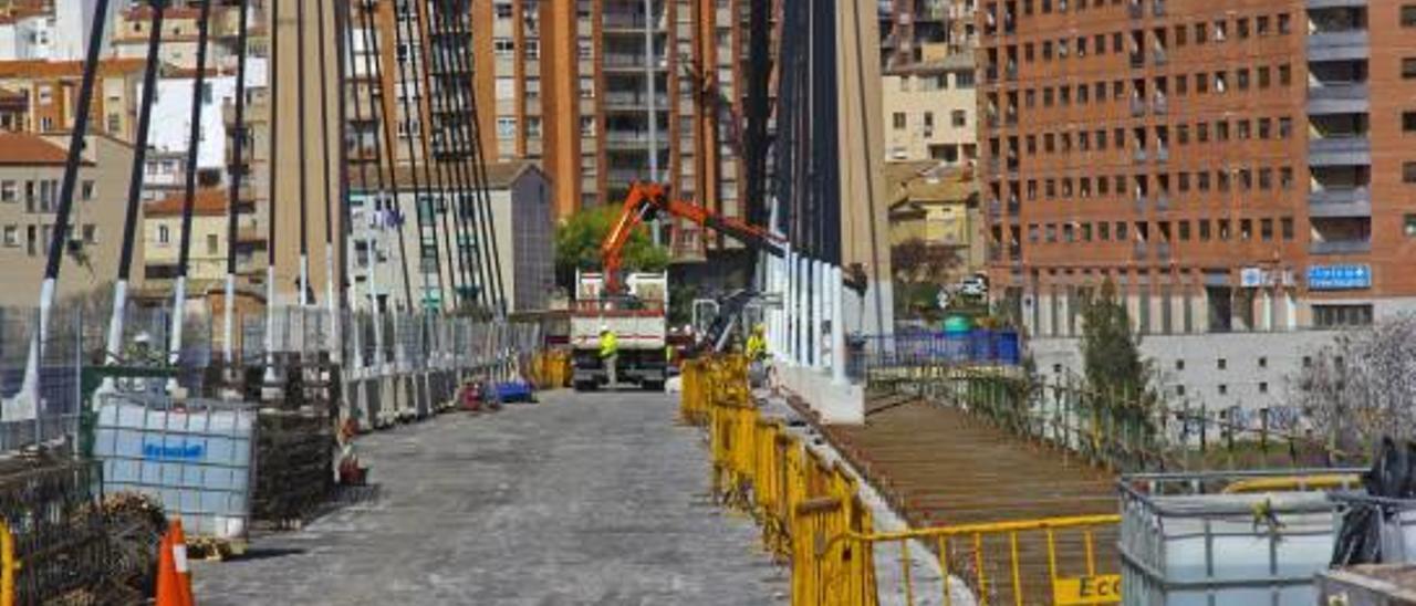 Una parte de la calzada, la acera y la barandilla del puente ya ha sido retiradas, preparándose su reposición; a la derecha, detalle de los trabajos en curso.