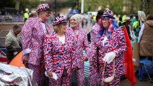Simpatizantes vestidos con la bandera británica, en Londres, aguardan los actos de celebración de la coronación.