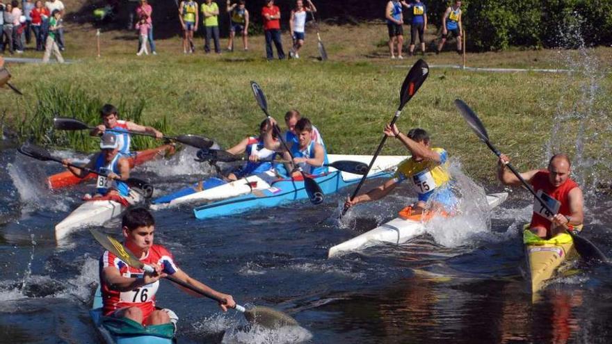 Una salida de una prueba de piragüismo desde la playa fluvial de Lantaño.