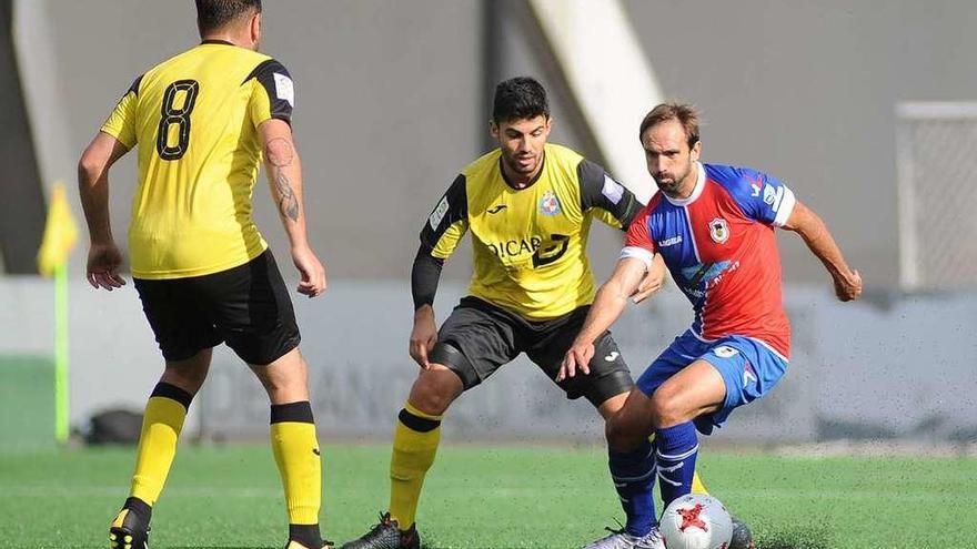 Aimar Gulín controla el balón ante dos jugadores del Llanera.