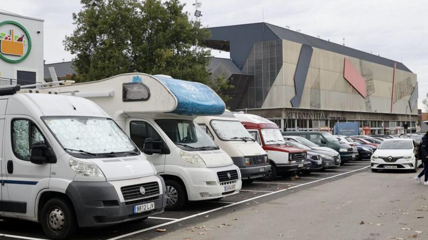 Vehículos estacionados en una de las zonas de aparcamiento del entorno del Molinón, al fondo. | MARCOS LEÓN