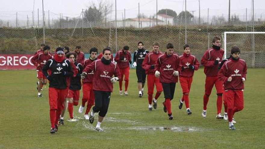 Los jugadores rojiblancos durante el calentamiento de la sesión de trabajo de ayer.