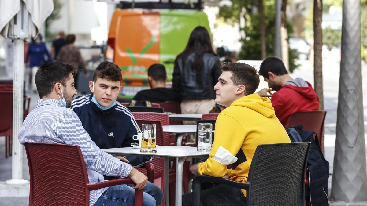 Jóvenes en una terraza en un local de Cáceres.