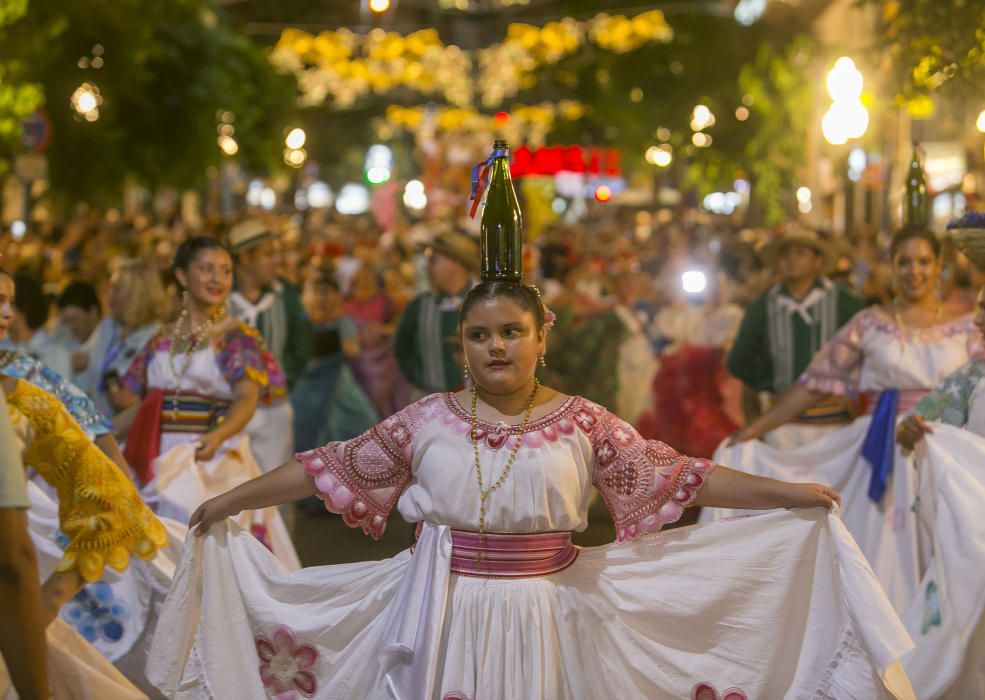 El desfile folclórico internacional de las Hogueras de Alicante llena de color las calles de la ciudad