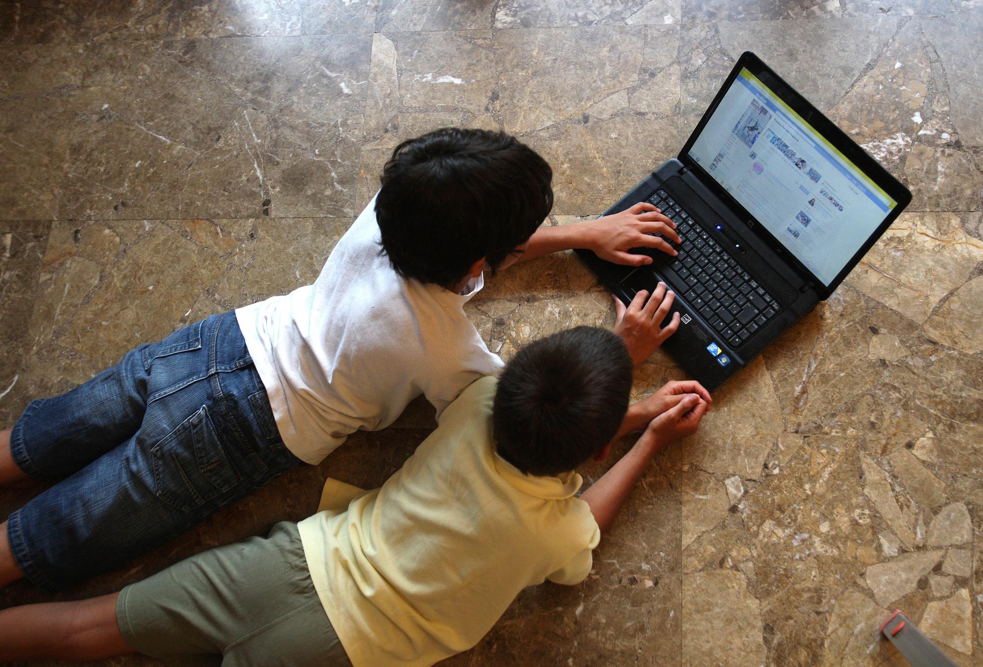 Niños miran Facebook en un ordenador.