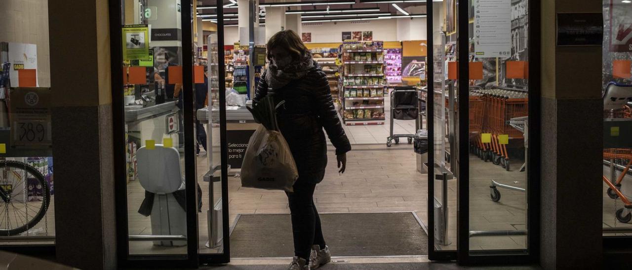 Una mujer abandona un supermercado casi vacío, a las puertas del toque de queda. |