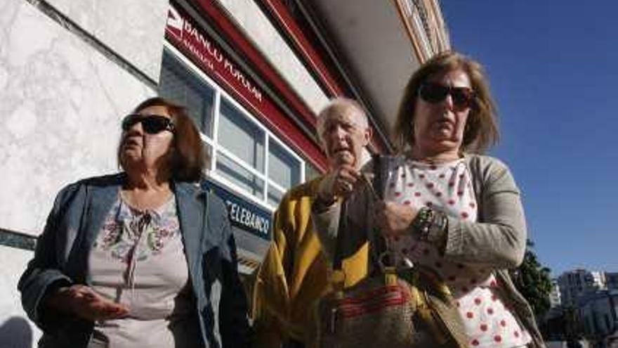 André Grajeal, su esposa Rosa Morales y su hermana Rosa tras salir de negociar con el Banco Popular.