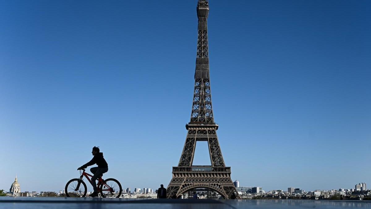 Un niño circula en bicicleta por los alrededores de la Torre Eiffel