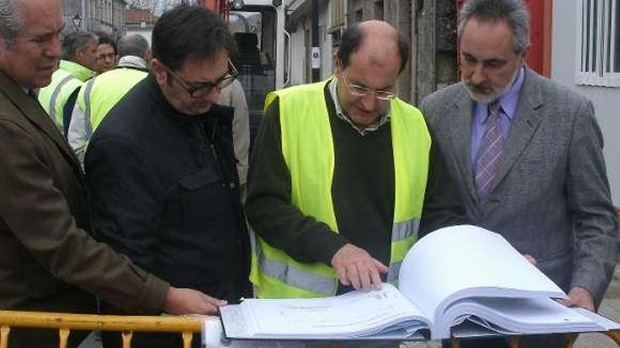Autoridades y técnicos comprueban los planos de la obra.