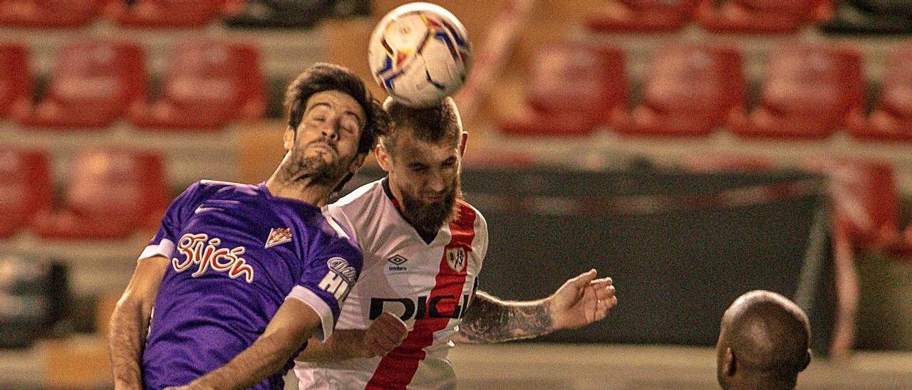 Marc Valiente y Saveljich disputan un balón aéreo en Vallecas.