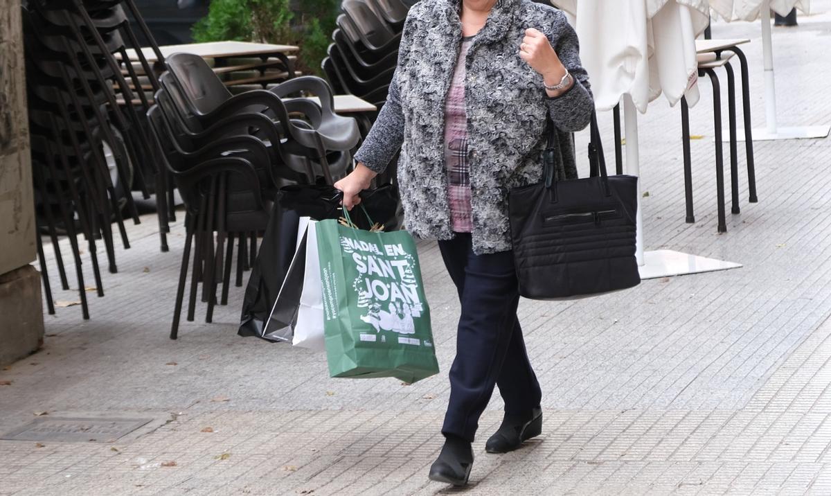 Una mujer lleva una de las bolsas de la anterior campaña de bonos comercio en Navidad.