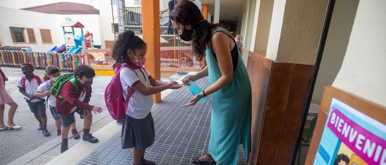 Una niña se pone gel hidroalcohólico para entrar al colegio Corpus Christi, en Palma.