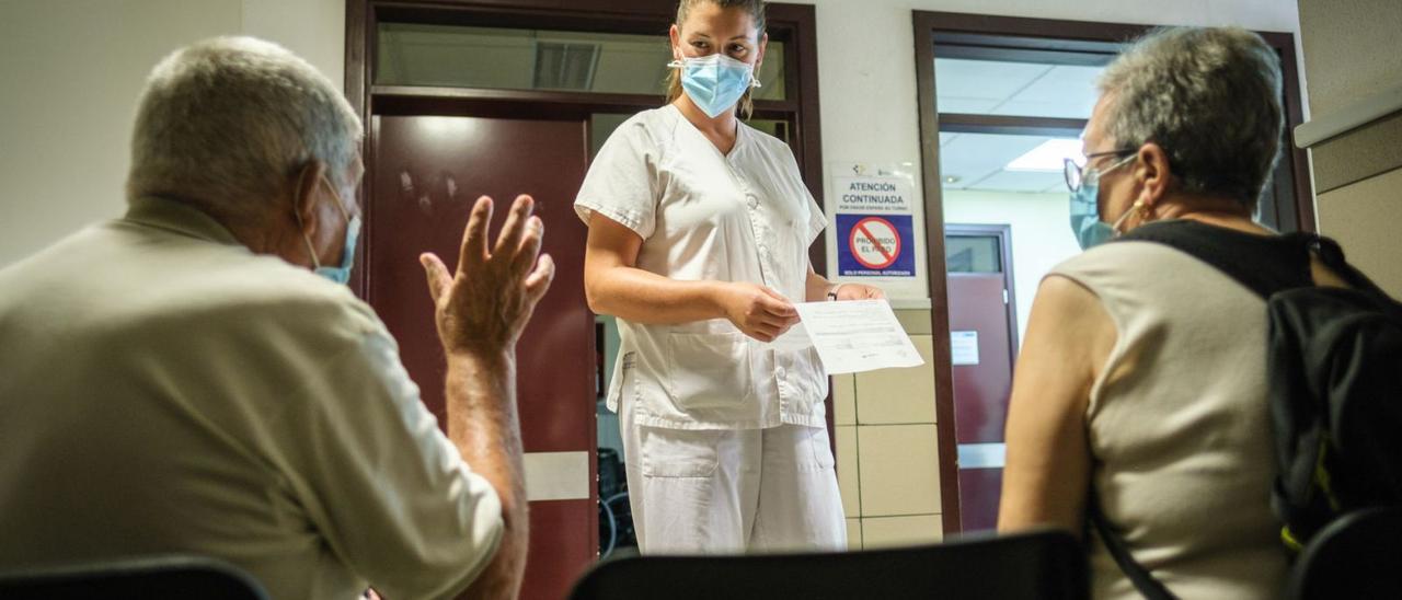 Una sanitaria atiende a una pareja de mayores en un centro de salud. | |