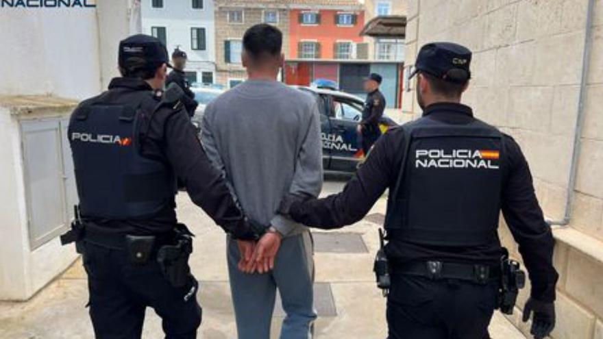 Dos agentes conducen al detenido por apuñalar al menor en Maó.