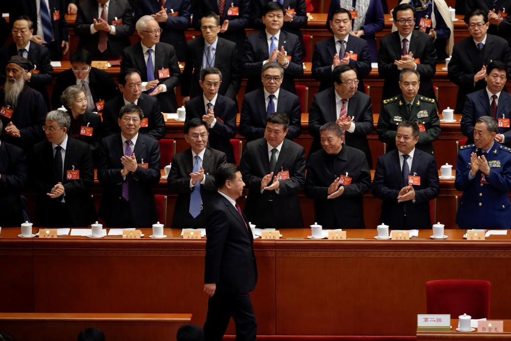 Ministros chinos aplauden a su presidente Xi Jinping.