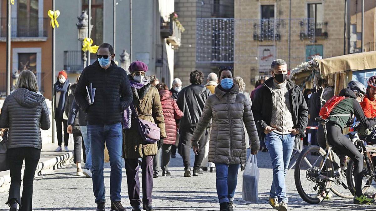 Gent passejant per les paradetes de Nadal del pont de Pedra de Girona, les passades festes.