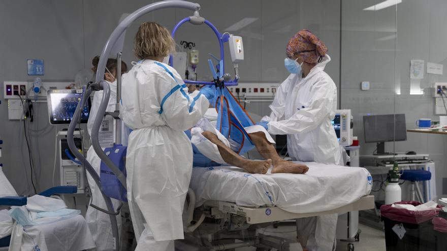 Varios sanitarios alrededor de un paciente ingresadopor COVID en un hospital.