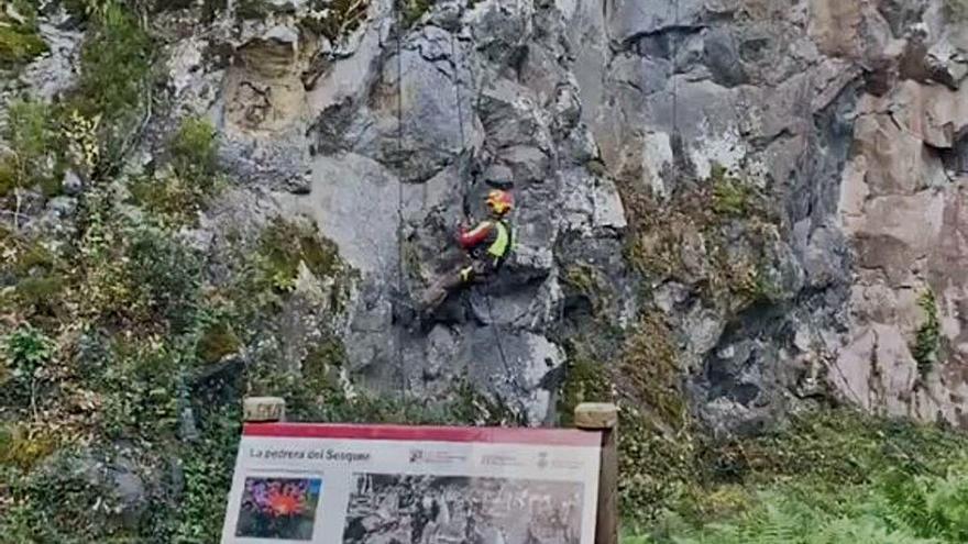 Un especialista treballa penjat a la pedrera del volcà Puig Roig.