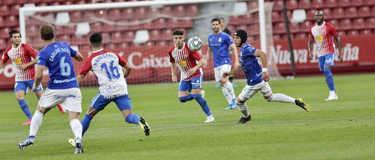 Una acción del Sporting-Oviedo de la pasada temporada, que se disputó a puerta cerrada en El Molinón