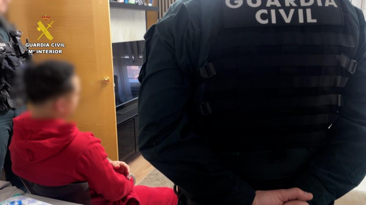 El detenido en Gijon, durante el registro de su vivienda.