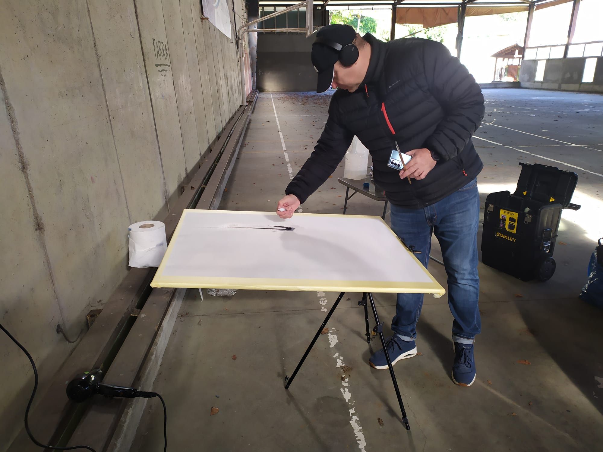 Néstor López Casas pintando en el polideportivo de Villanueva.