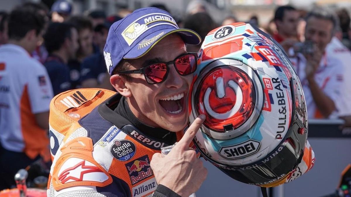 Marc Márquez señala, feliz, el interruptor que tiene dibujado sobre su casco.