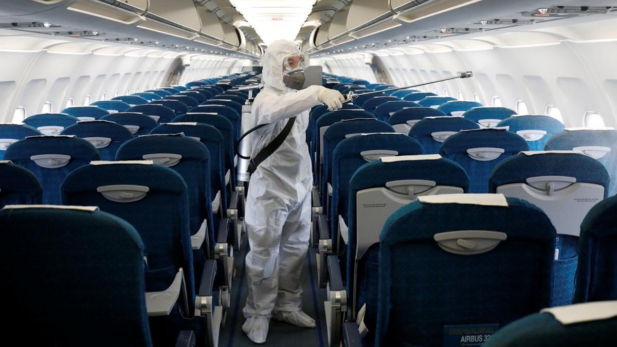 Un operario desinfecta un avión de Vietnam Airlines como prevención ante el coronavirus.