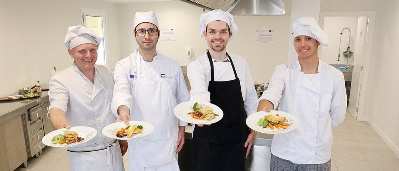 El cocinero Juan Acuña con sus alumnos Daniel Rodríguez, Fabián da Silva y Gabriel Gil, durante la clase de ayer.