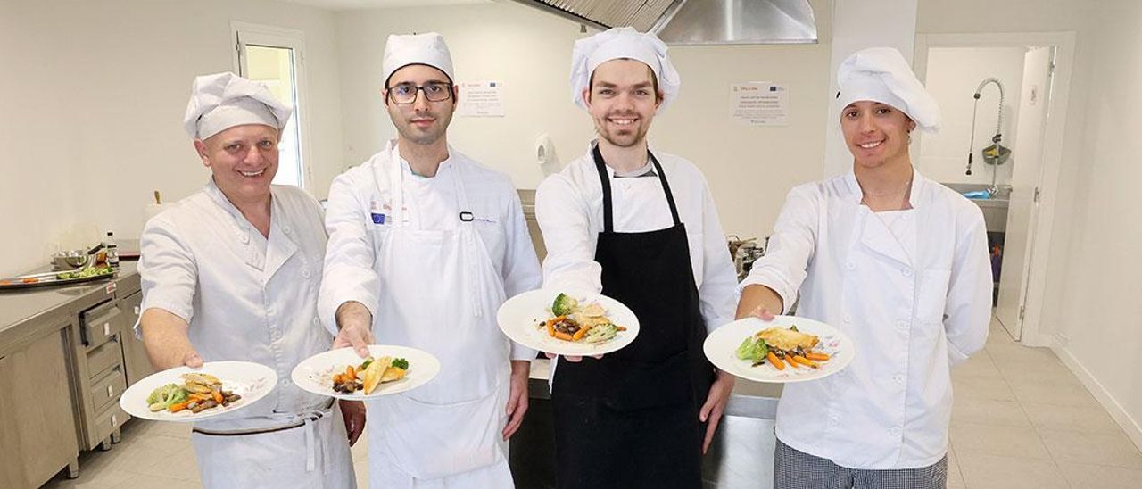 El cocinero Juan Acuña con sus alumnos Daniel Rodríguez, Fabián da Silva y Gabriel Gil, durante la clase de ayer.