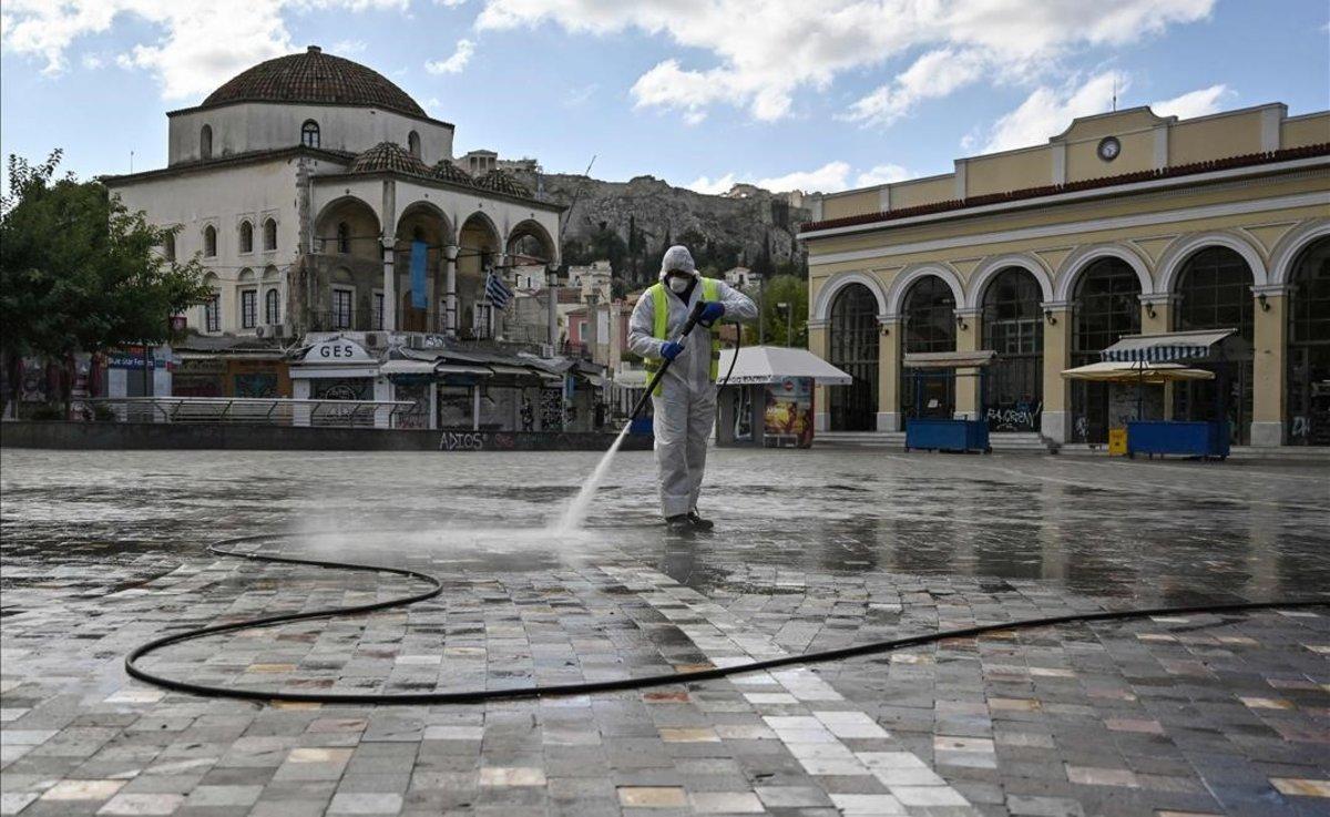 Un trabajador de la limpieza desinfecta la normalmente concurrida plaza de Monastiraki.
