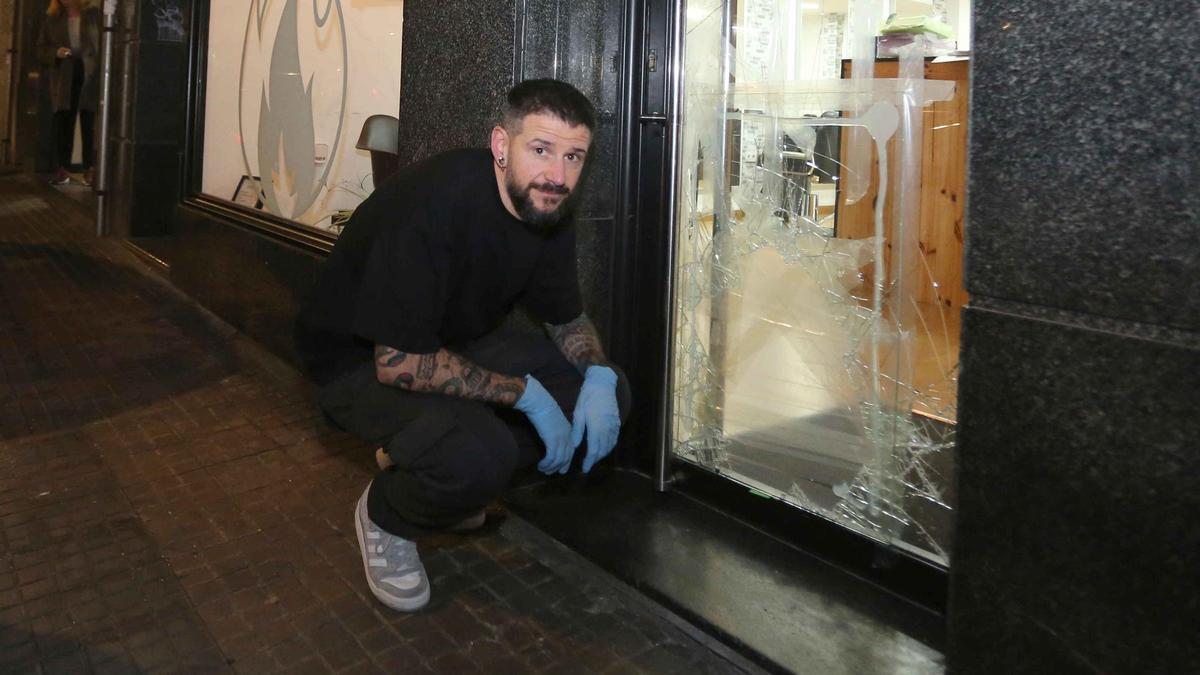 José Rivas junto a la puerta rota de su negocio en A Cubela.