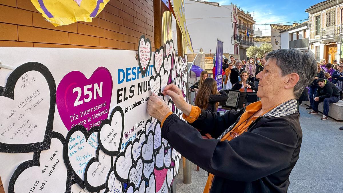 Una mujer pone un mensaje en el mural