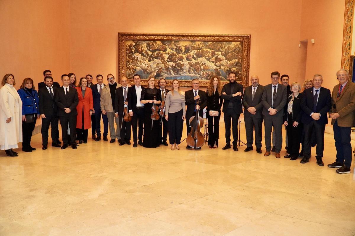 Algunos de los asistentes posan ante una de las obras.