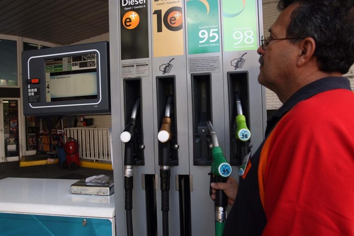 Un treballador posa gasolina en una estació de servei de Barcelona.