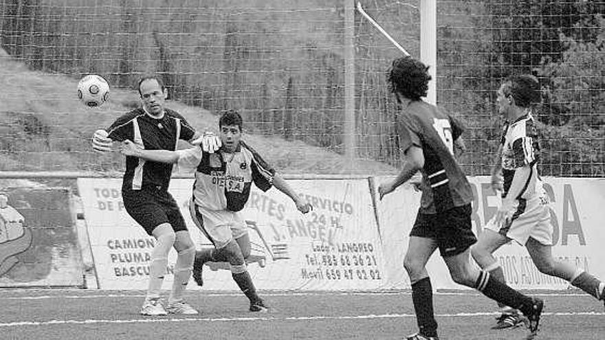 El portero visitante Noguerol trata de hacerse con el balón presionado por el arlequinado Edu.