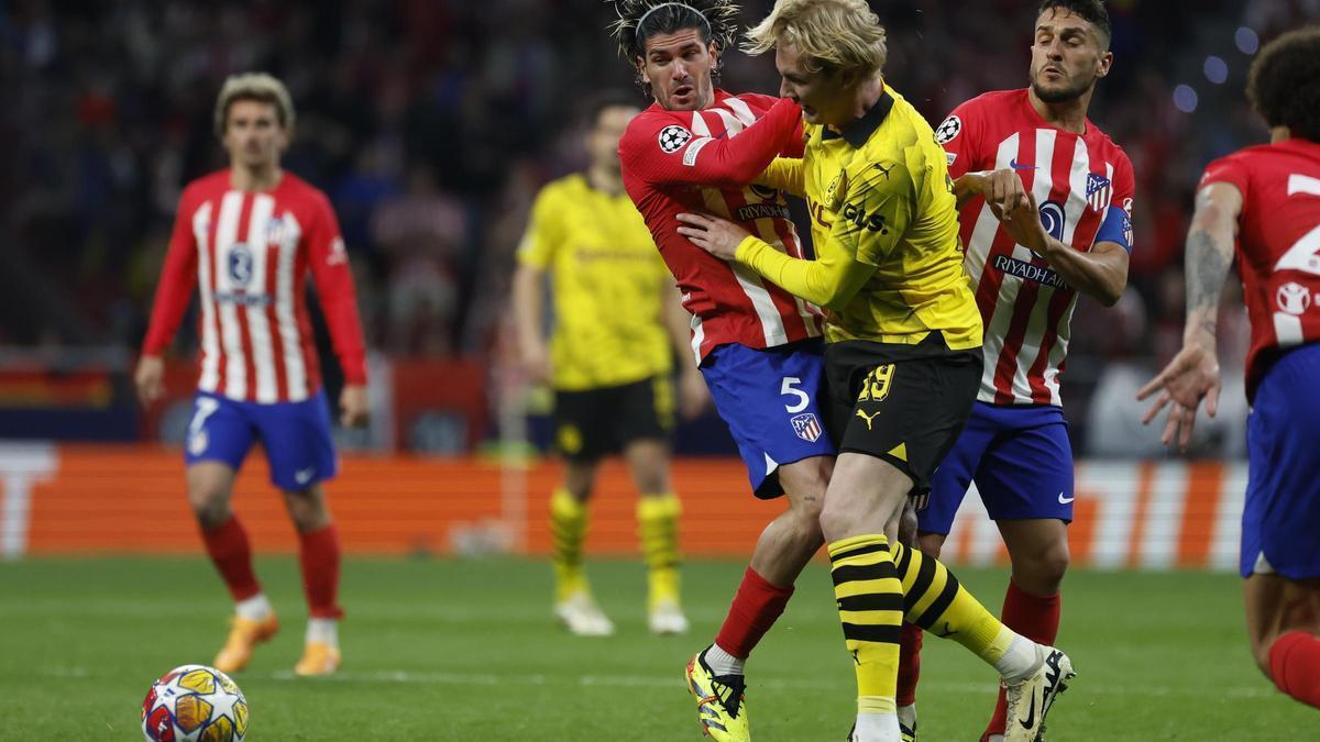 Rodrigo de Paul, jugador del Atlético, lucha por un balón con Julian Brandt, del Borussia Dortmund.